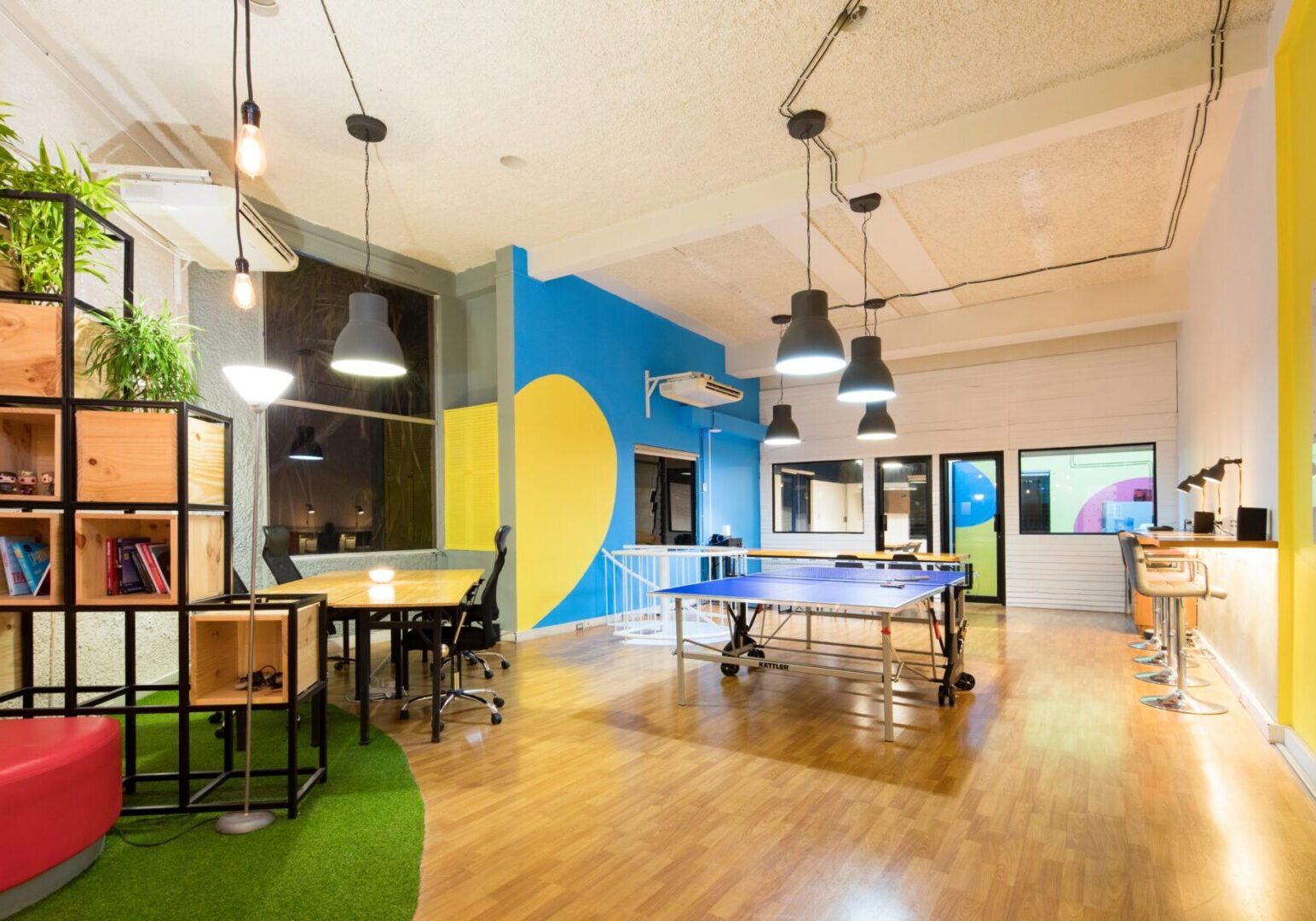 An office with ping pong tables and colorful walls.